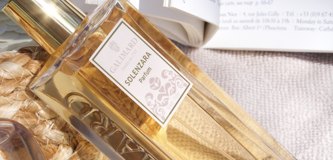 Flacon de parfum femme au soleil à côté d'un livre et posé sur un sac d'été en toile de jute