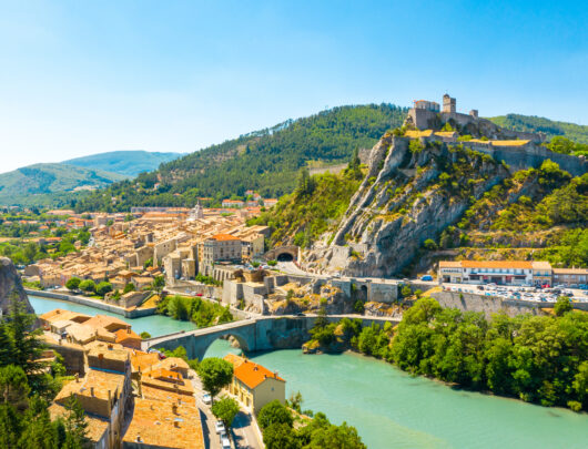 Village du Sud de la France ensoleillé avec rivière.